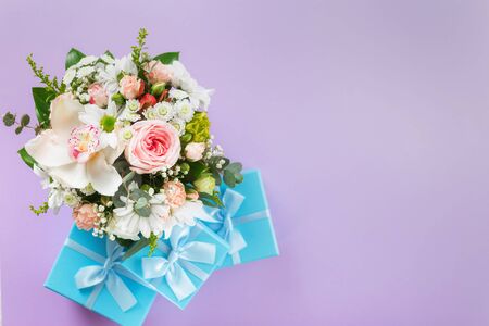 Top view flower bouquet on purple background with gift boxes copy space flat layの写真素材