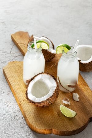 Coconut with coconut water in bottles on light background. Healthy drinks conceptの写真素材