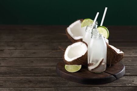 Coconut water in bottles on wooden table. Healthy veggie drinkの写真素材