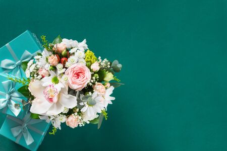 Flower bouquet with gift boxes on green background  copy space flat lay top viewの写真素材