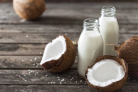 Coconut kefir in bottles on wooden table. Healthy eating concept. Fermented drinksの写真素材
