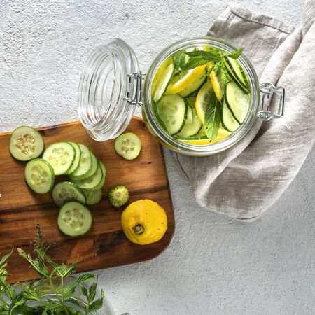 Detox water with cucumbers and lemon in glass jar on white background top viewの写真素材