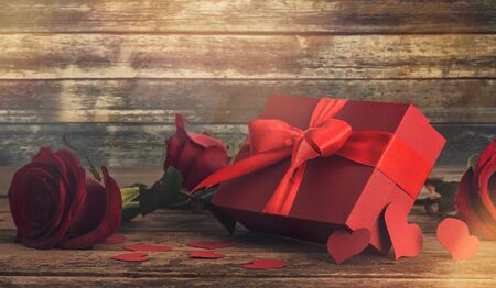 Valentines day concept. Red gift box with red rose and heart on wooden backgroundの写真素材
