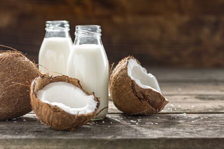 Coconut kefir in glass bottle on wooden table. Vegan non dairy healthy or fermented drink. Healthy eating conceptの写真素材