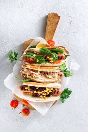 Different hot dog grills served in wooden board on light background. Copy space top viewの写真素材