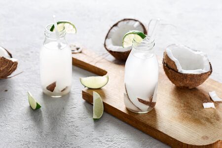 Coconut water in bottles on light background. Healthy drinks conceptの写真素材
