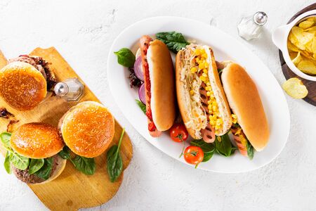 Party dinner table with different homemade hot dogs and burgers top viewの写真素材