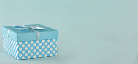 Blue polka dot gift box with bow on blue background Copy spaceの写真素材