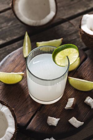 Fresh coconut water in glass cup on wooden tableの写真素材