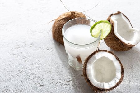 Fresh coconut water in glass cup on light backgroundの写真素材