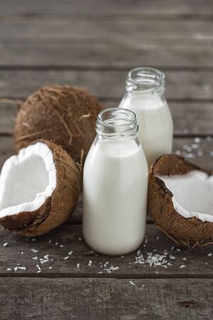 Coconut kefir in bottles on wooden table. Healthy eating concept. Fermented drinksの写真素材