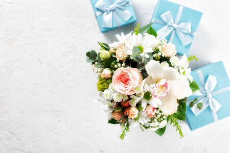 Flower bouquet with gift boxes on white background Flat lay, top view floral Valentine's Day or Mother's Day concept Copy spaceの写真素材