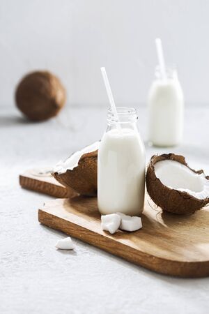 Coconut kefir in glass bottle on light background. Vegan non dairy healthy or fermented drink. Healthy eating conceptの写真素材