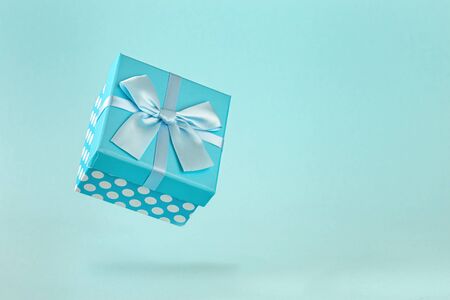 Blue polka dot gift box with bow on blue background Copy spaceの写真素材