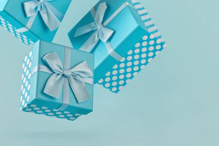 Blue gift boxes with ribbons on blue background Copy space