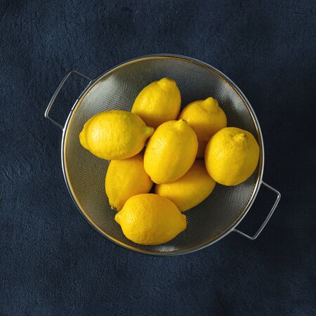 Ripe lemon on a dark background with strainer top viewの写真素材