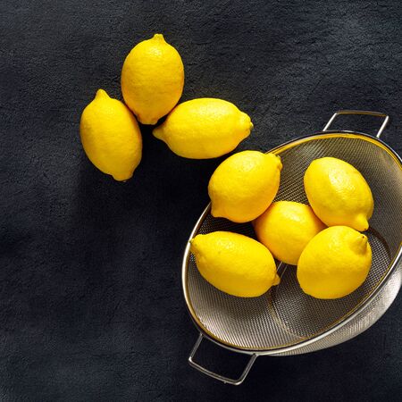 Ripe lemon on a dark background with sieve top viewの写真素材