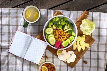 Open notebook with blank pages with plate of fresh vegetarian food top view. Balanced diet foodの写真素材