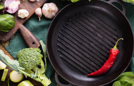Empty grill pan with fresh vegetarian various ingredients for cooking vegan grilled food overhead viewの写真素材