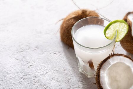 Fresh coconut water in glass cup on lightの写真素材