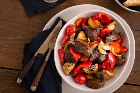 Plate fried beef meat, new potatoes and vegetables top viewの写真素材