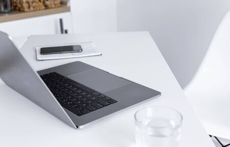 Home office with computer, notepad, glass of water and smartphone.の写真素材