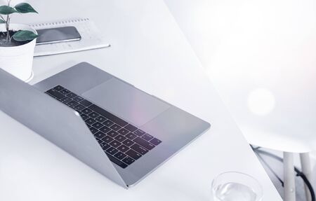 Laptop on white office or home table Remote work or online learning concept Freelancer workspace