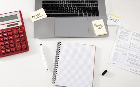 Payment of taxes or bills concept. Office desk with notebook, calculator, laptop and utility billsの写真素材