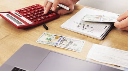 Tax payment concept. Business man using calculator for calculating taxesの写真素材