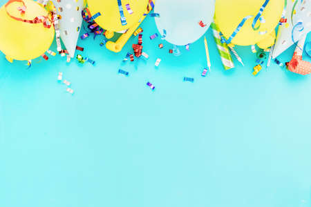 Birthday balloon background with colorful party streamers, confetti and birthday party hats blue...