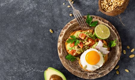 Sandwiches for breakfast with avocado puree, fried egg and vegetablesの写真素材