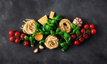 Fettuccine with ingredients for cooking italian pasta on dark background, top viewの写真素材