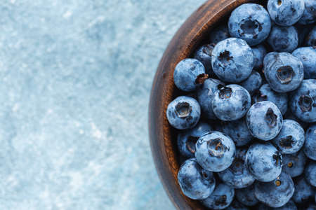 Fresh blueberries in wooden bowl close up top viewの写真素材