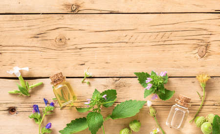 Various plants, leaves of healing herbs and healthy oils on wooden background top view. Alternative medicine backgroundの写真素材