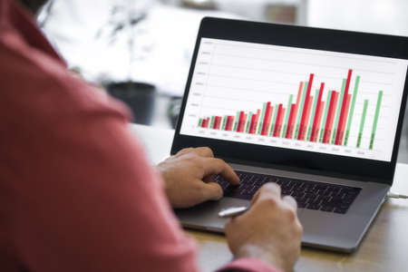 Male analyst analyzes report while sitting at home. Remote work conceptの写真素材