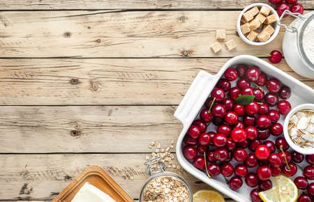 Ingredients for cooking pie with cherries on wooden table with copy space top viewの写真素材