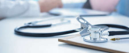 Stethoscope and clip board on the doctor workplace close upの写真素材