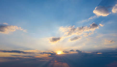 Beautiful sunset or dawn with bright sun breaking through cloudsの写真素材