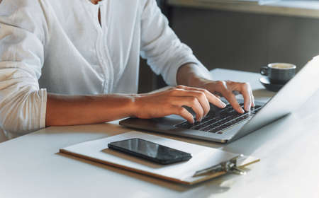 Closeup woman hands typing on the keyboard using laptop while working or study from home. Education or work online. Remote work concertの写真素材