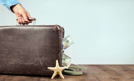 Retro suitcase full of money on blue background creative travel concept Copy spaceの写真素材