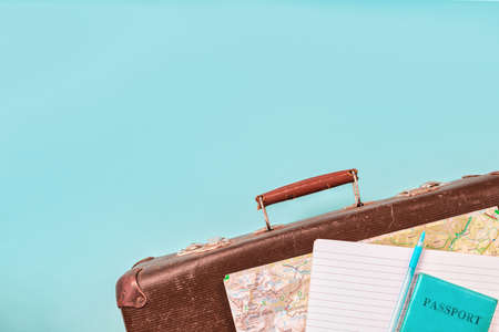 Old suitcase with map and passport with money on blue background creative travel concept Top view Copy spaceの写真素材