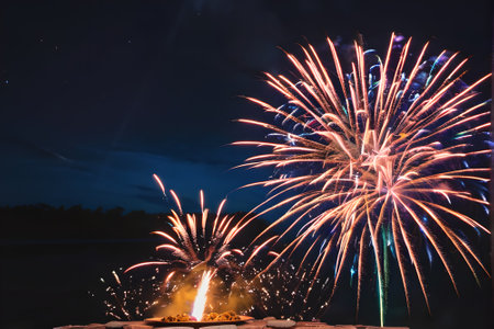 Colorful fireworks of various colors over dark night sky background for celebrationの素材