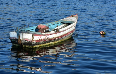 Old fishing boat or better rowboat in the port of Havana, Cuba. The name 'El loco' fits the boat. The plastic bottle as reinforcement of the buoy is interesting.の写真素材
