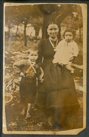 A woman in a skirt with her unidentified children - circa 1920