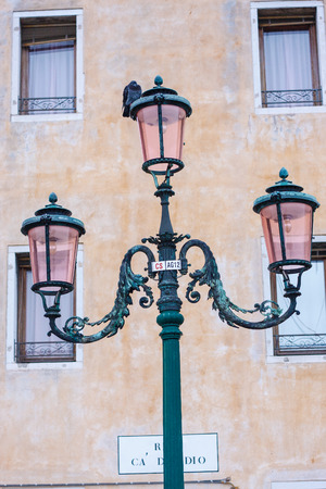 Street lamp in Venice with pigeon sitting on it.の写真素材