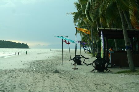 The hut under coconut trees at the sandy beachの写真素材