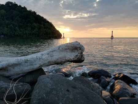 Watching sunset at the rocky beachの写真素材