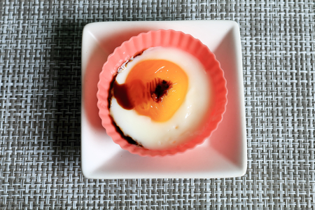 Fried egg. The eggs were placed in a silicon cup cooked in a microwave oven.の写真素材