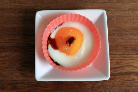 Fried egg. The eggs were placed in a silicon cup cooked in a microwave oven.の写真素材