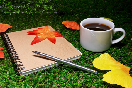 coffee, note and fake fallen leavesの写真素材